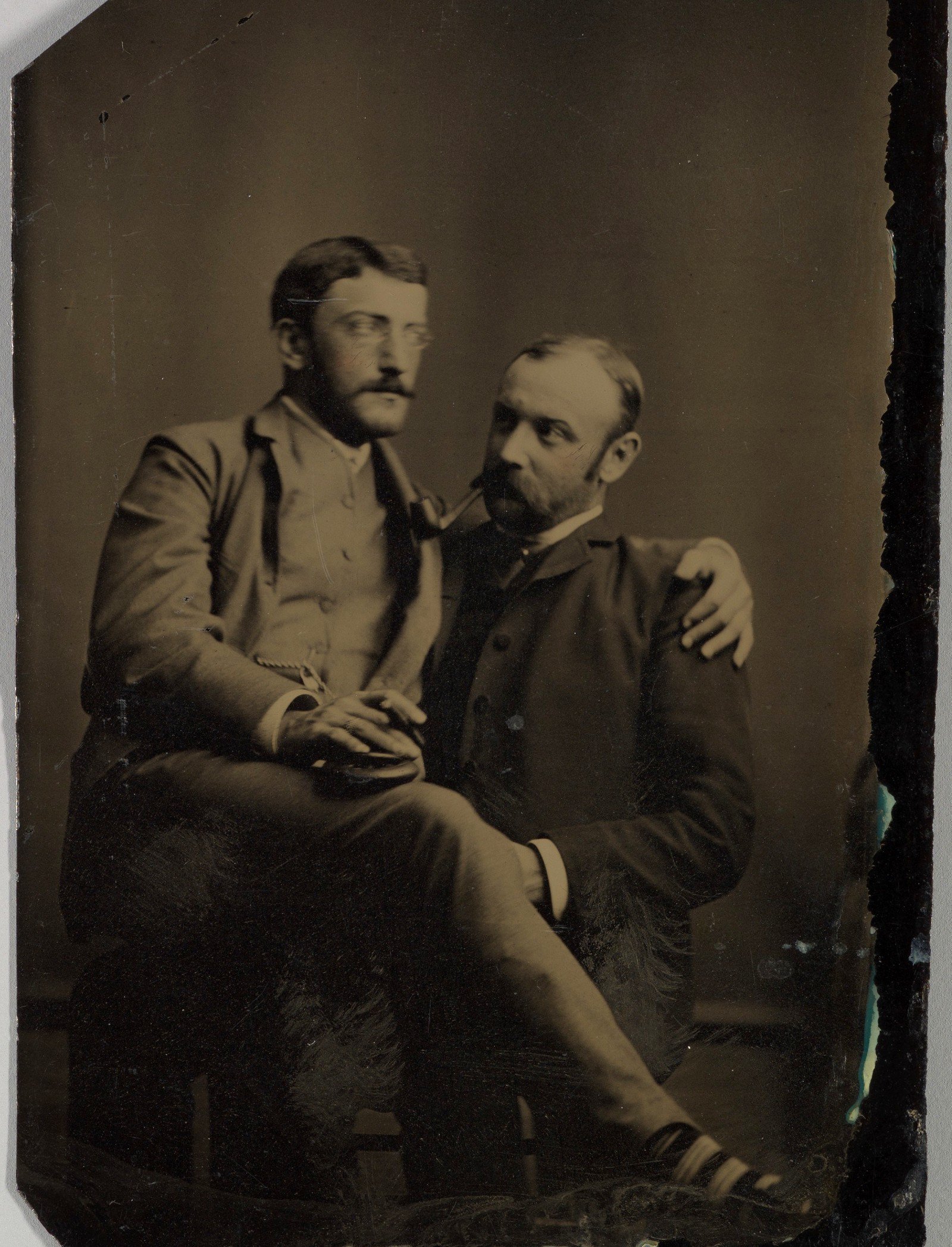 Двое мужчин курят, один сидит на коленях у другого; тинтайп, фотография неизвестного автора, 1880–1890-е годы